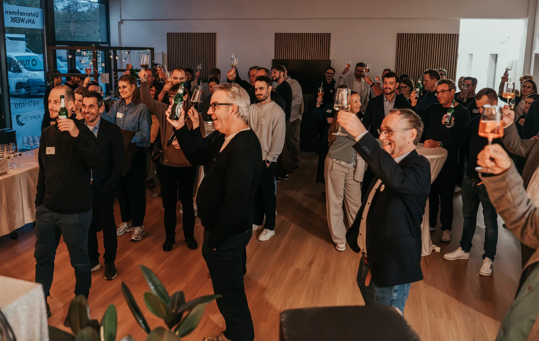 Alle Gäste heben beim Get-together die Gläser
